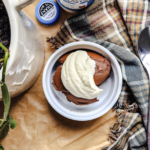 picture of chocolate mousse in a white bowl with a dollop of whipped cream