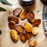 roasted baby potatoes laying on parchment paper on the counter in the sun