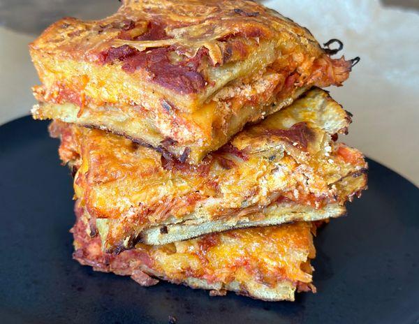 Layered enchilada casserole with seasoned chicken, melted cheese and yummy tortillas.