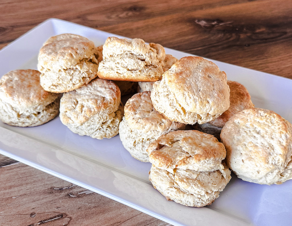 Freshly baked einkorn flour biscuits on a white platter.