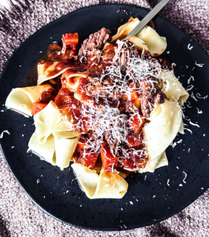 A close-up of beef ragu showcasing the primary ingredients and visualt elements.