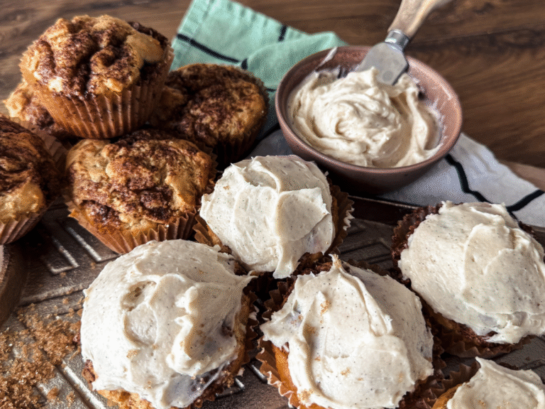 5 cinnamon rolls iced and 3 non iced piled on a gold platter.