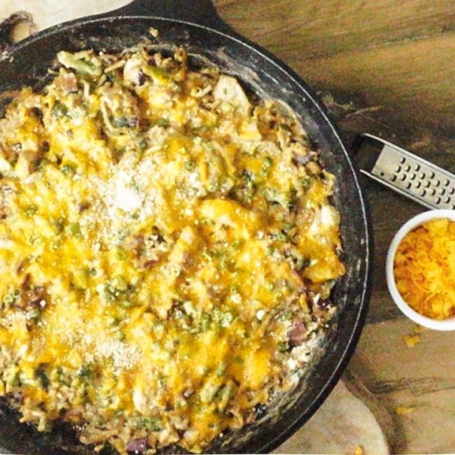 A cast iron skillet filled with jalapeno popper chicken casserole