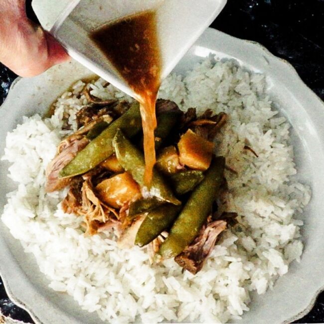 Sweet and Sour Pork Butt with Vegetables served over rice. The juices are poured over top.