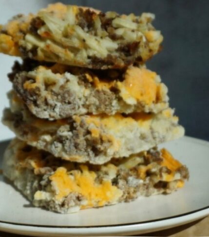 Square slices of sausage, potato and cheese stacked up.