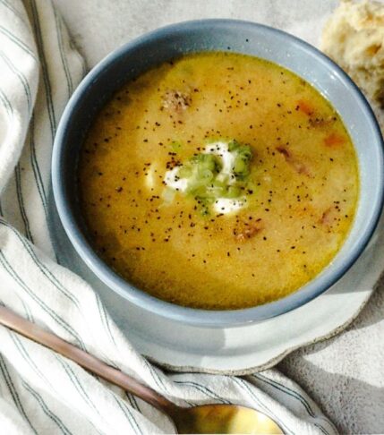 Creamy Sausage and Potato Soup in a blue bowl with a white background.