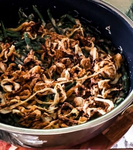 Green Bean Casserole in a skillet with crispy onions on top.