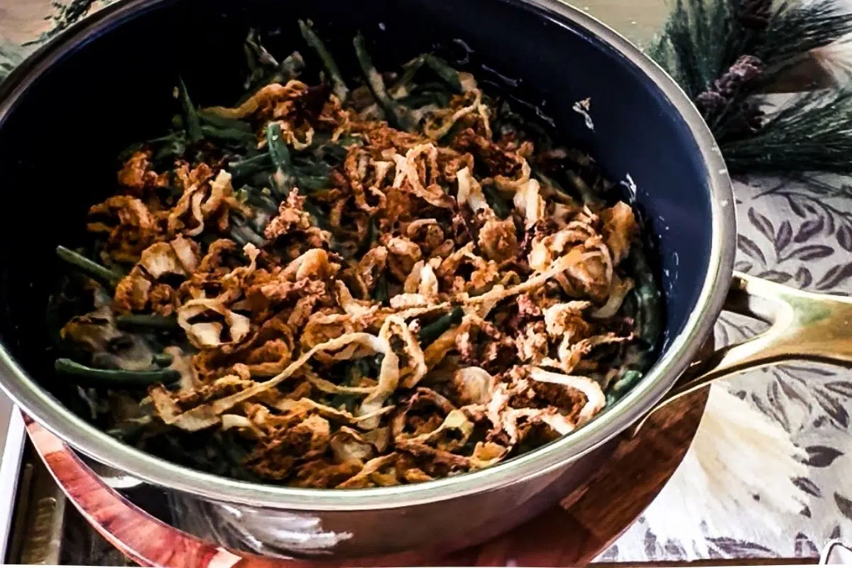 Green Bean Casserole in a skillet with crispy onions on top.