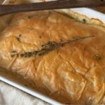 Chicken and Leek bake in a white dish with a flaky phyllo crust.