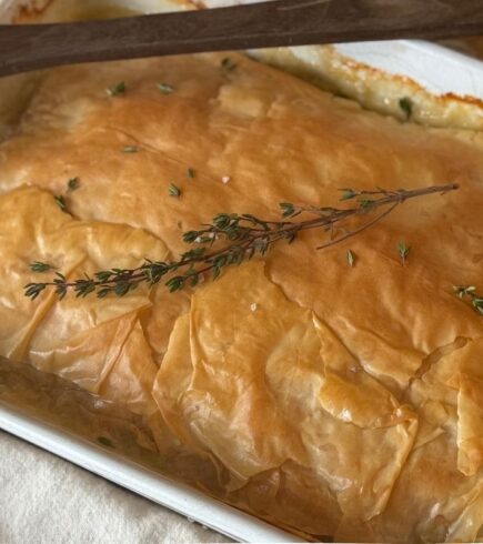 Chicken and Leek bake in a white dish with a flaky phyllo crust.